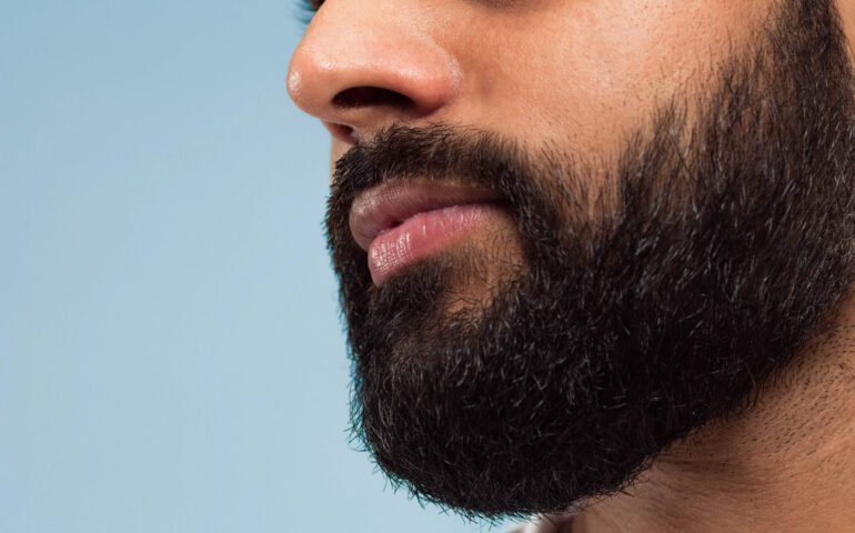 Close up portrait of young man on blue background.